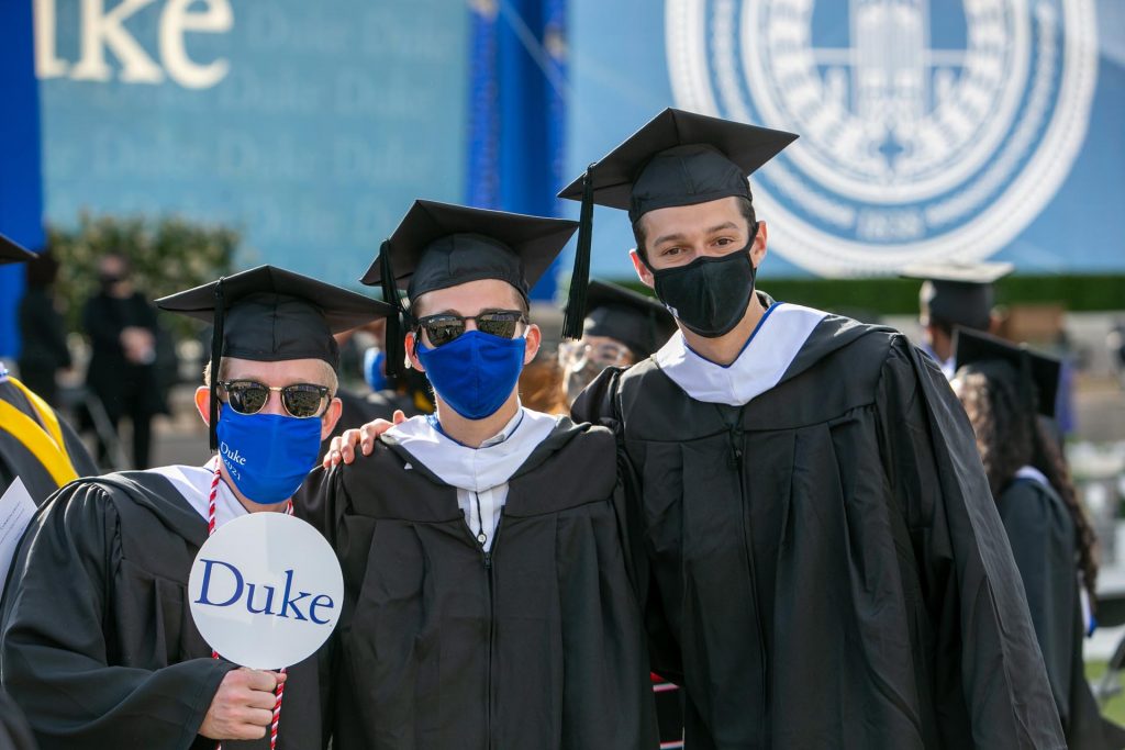 Three students pose for the camera while entering Wallace Wade Stadium.