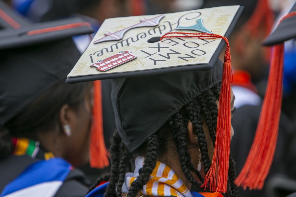 A Graduate with a decorated mortarboard that says, “On to my next adventure!”