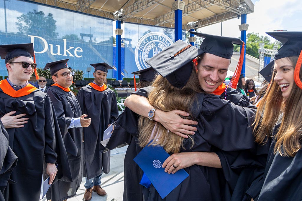 Two graduates hug as the celebrate commencement