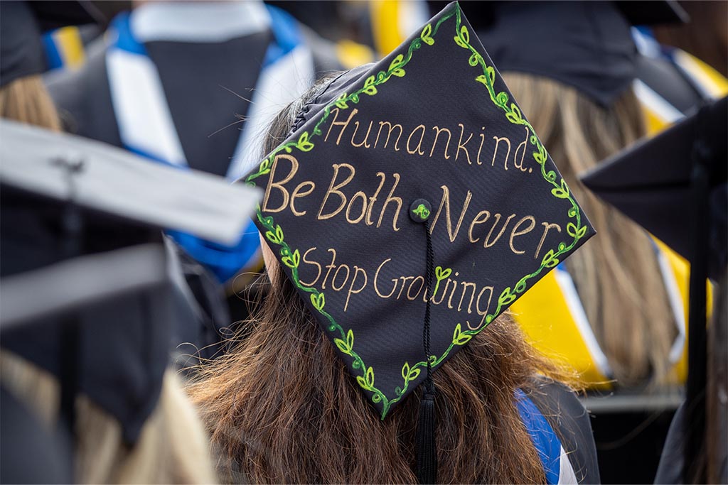 A decorated mortarboard that says, “Humankind. Be Both. Never stop growing.”